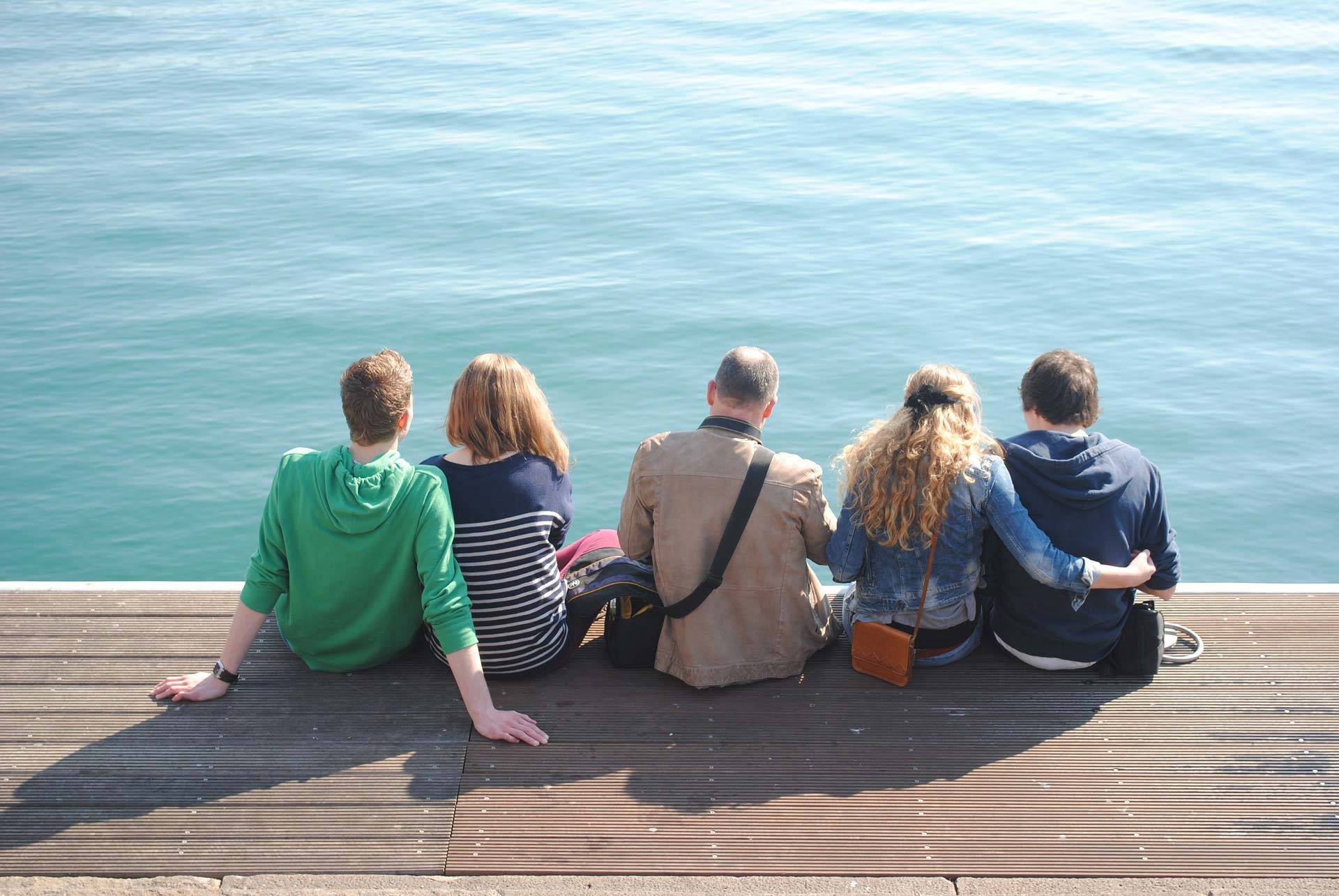 Gruppe sitzt gemeinsam am Wasser