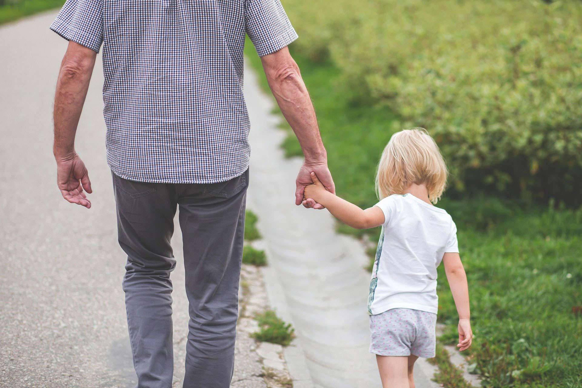 Vater und Tochter gehen Hand in Hand