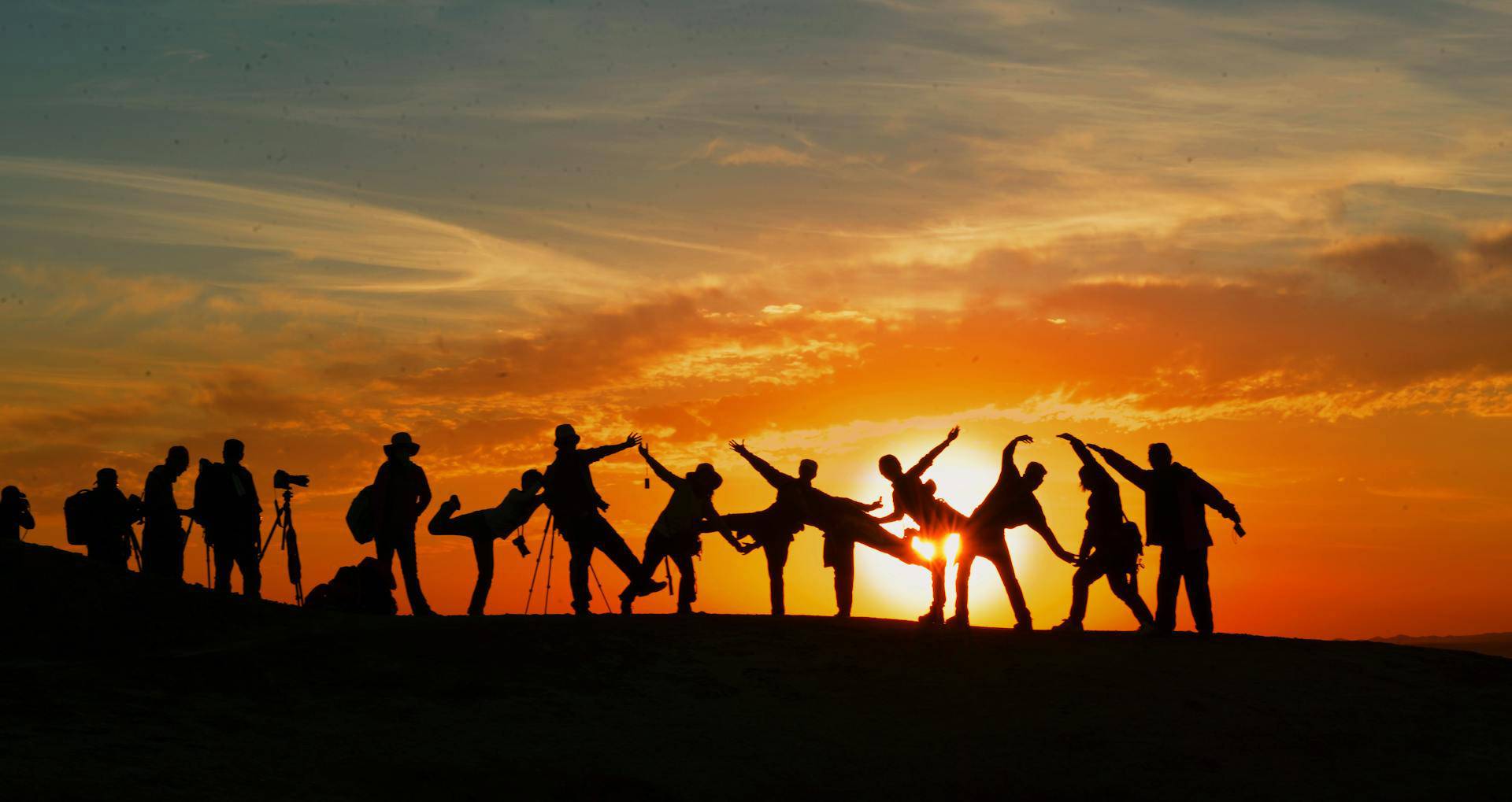 Gruppe springt im Gegenlicht der Sonne nach oben