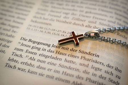 Kette mit Kreuz liegt auf der Bibel