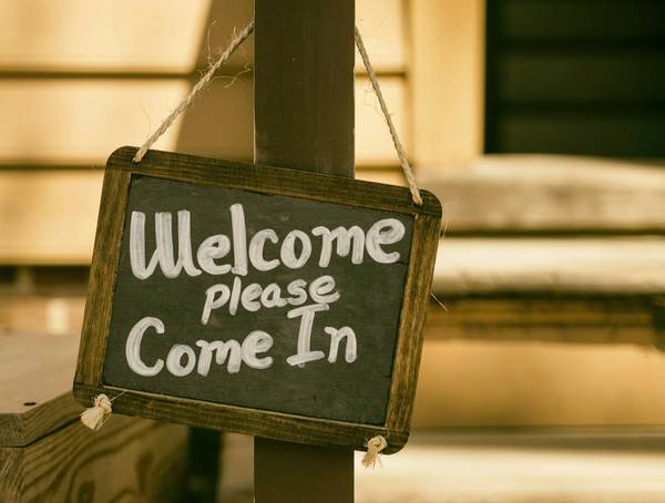 Kreidetafel mit der Aufschrift: Welcome please come in